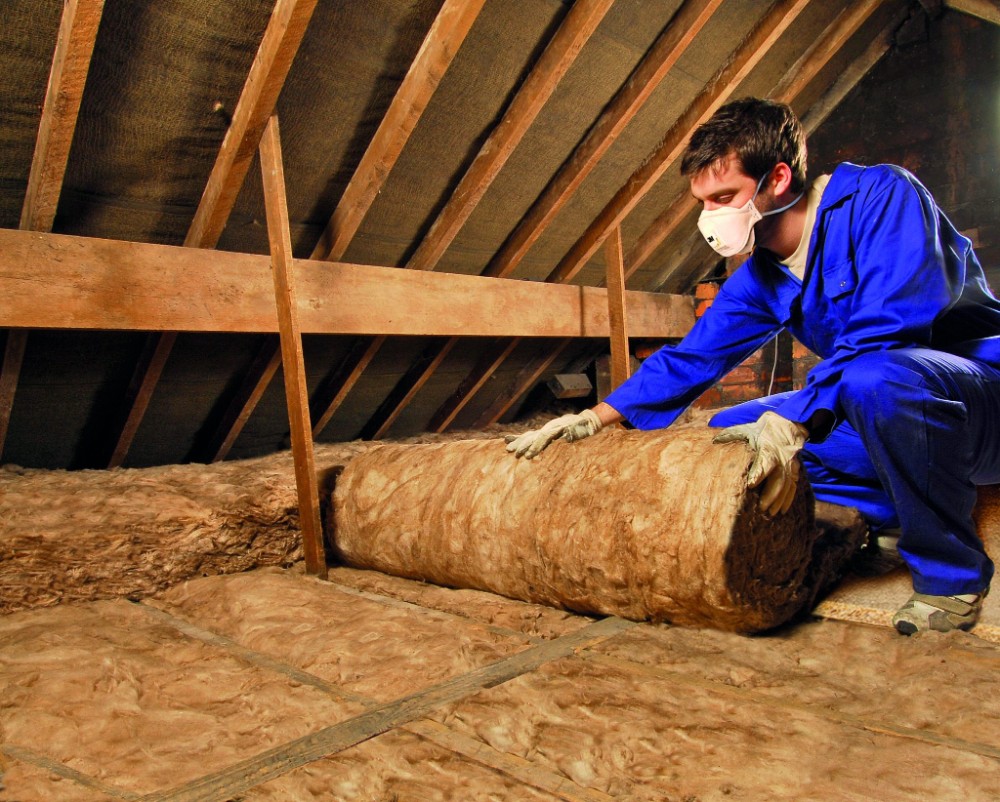 Loft insulation installers London - insulation being laid evenly in loft